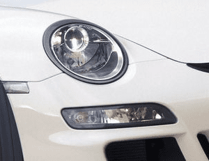 A close up of the headlight on a white car